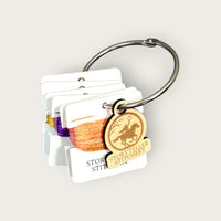 Headless Horseman hand-dyed thread cards in black, purple, gold, orange, and copper with a silver ring and horseman charm