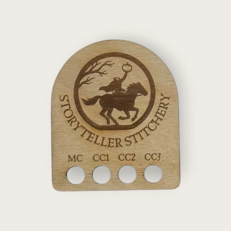 Birch yarn color organizer with holes labeled MC, CC1, CC2, and CC3 and an engraved Headless Horseman