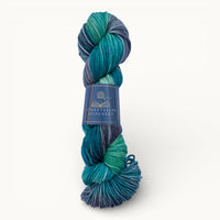 Blue and green skein of yarn with a label on a white background