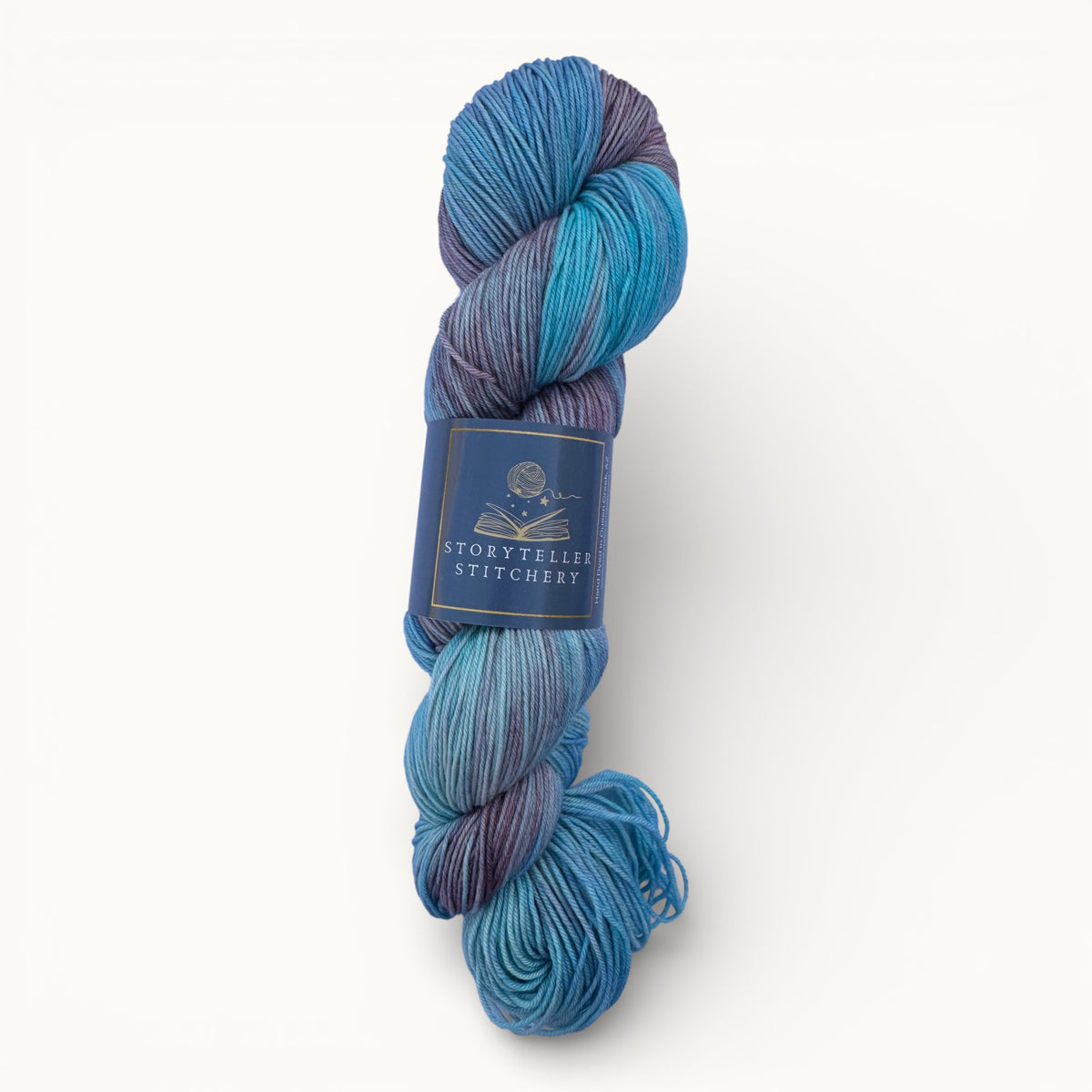 Blue and purple skein of yarn with a label on a white background