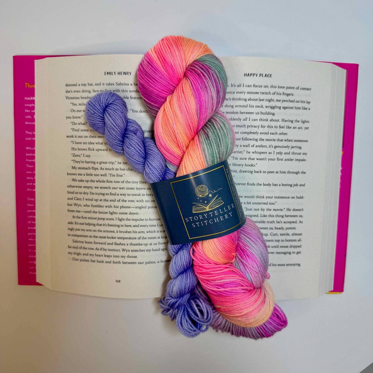 Hand-dyed yarn in bright beachy summer colors, inspired by Happy Place by Emily Henry. Storyteller Sock Set displayed on the open book.
