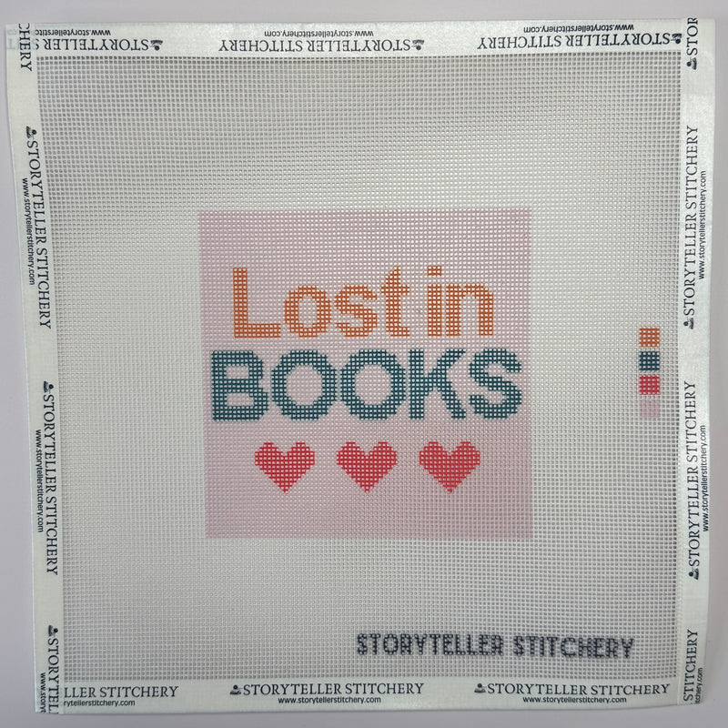 Needlepoint canvas with 'Lost in Books' text and heart symbols printed on canvas.