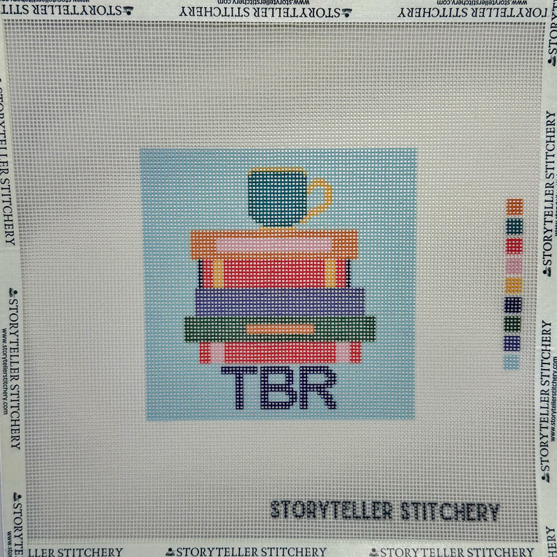 Needlepoint canvas with books and cup design labeled 'TBR' for To Be Read, by Storyteller Stitchery